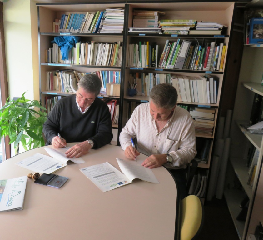 Federico Aja y Carlos Sánchez firmando el acuerdo.