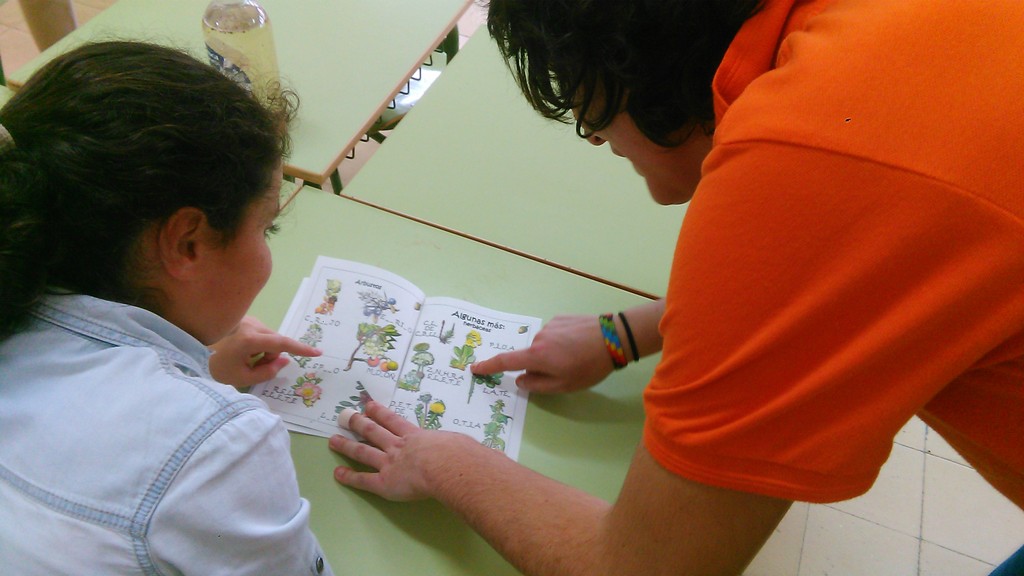 Monitora de FNYH enseñando las plantas a una alumna.