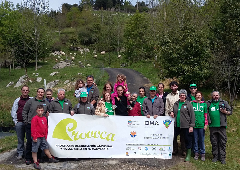 Voluntarios del PROVOCA sostienen la bandera del programa.