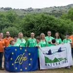 Un grupo de voluntarios que se congregó en los Pozos de Valcaba muestra las banderas del programa LIFE y la Red Natura 2000.